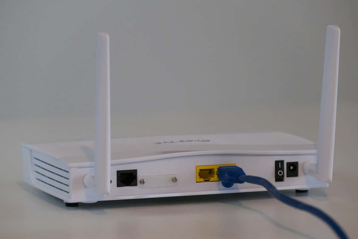 Witte wifi-router met antennes en een aangesloten netwerkkabel