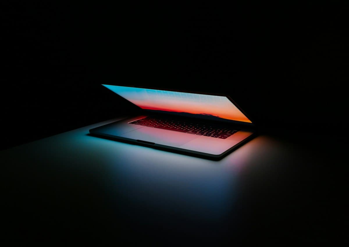 Opengeklapte laptop die zacht oplicht in het donker