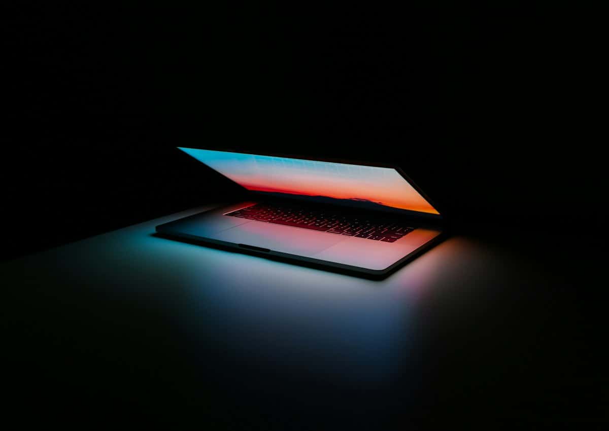 Opengeklapte laptop die zacht oplicht in het donker