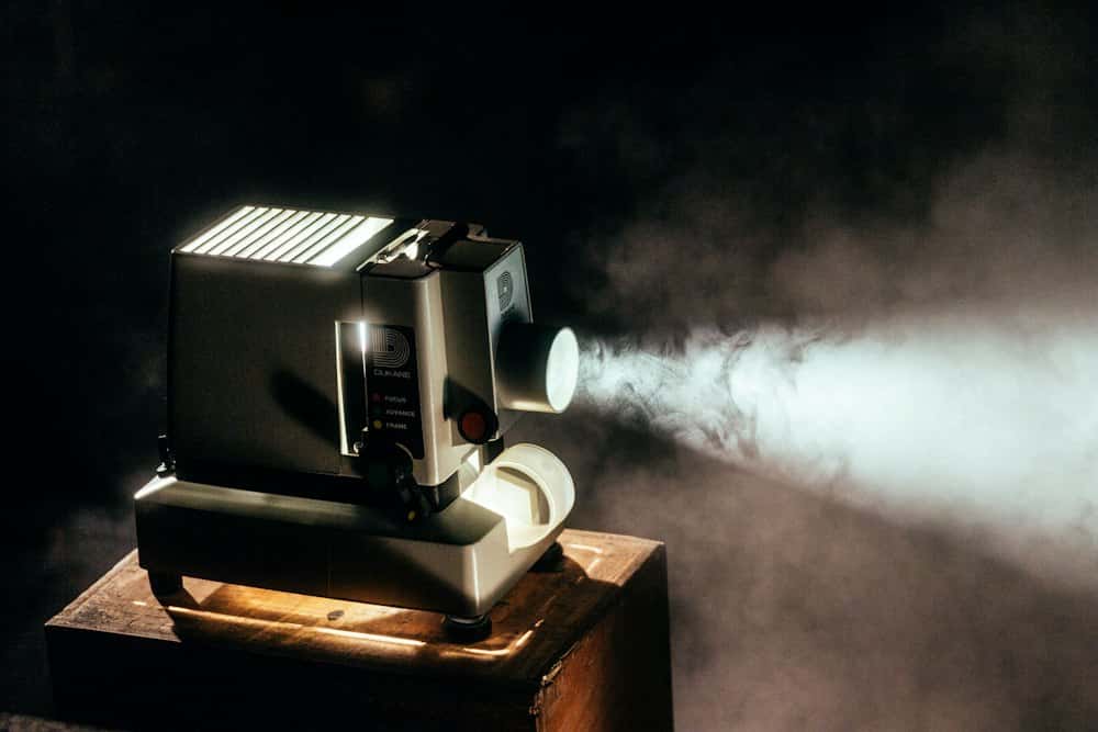 Filmprojector die een lichtbundel door de rook werpt