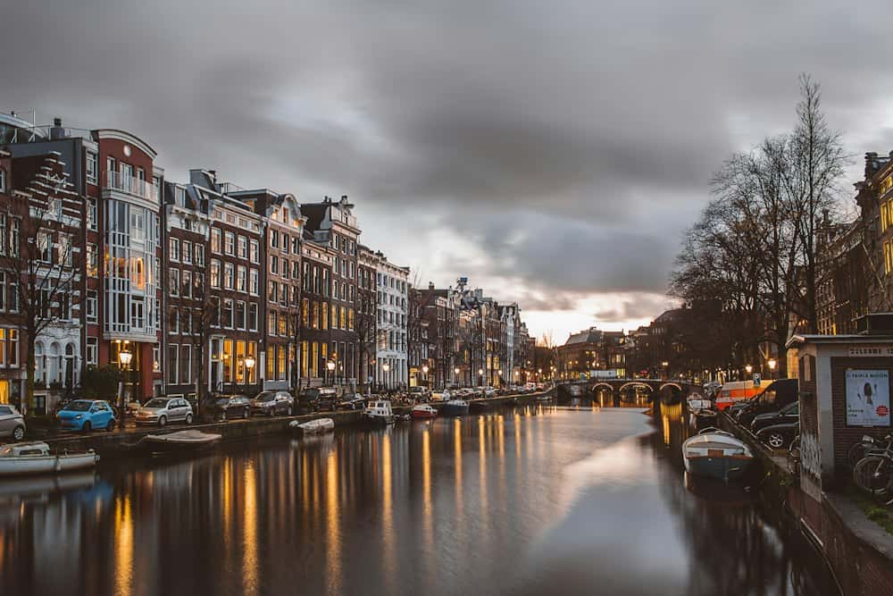Amsterdamse gracht met grachtenpanden in de avond