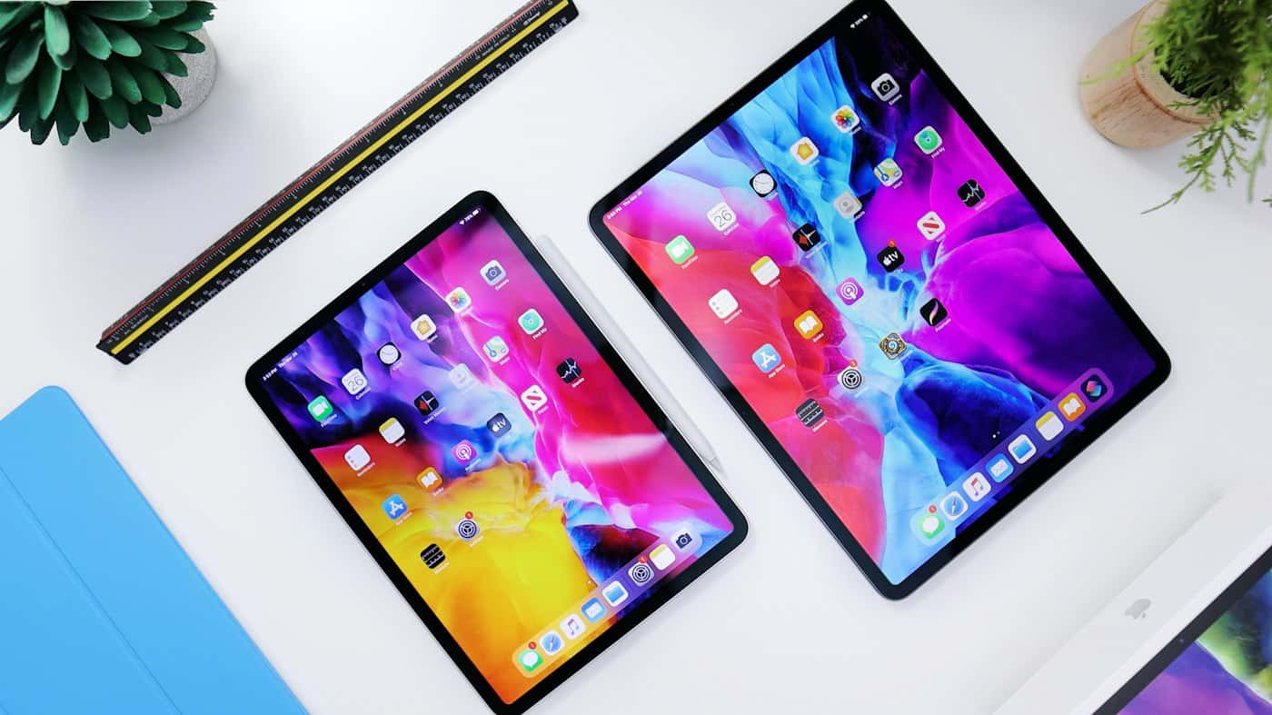 Twee tablets met kleurrijke schermen op een wit bureau