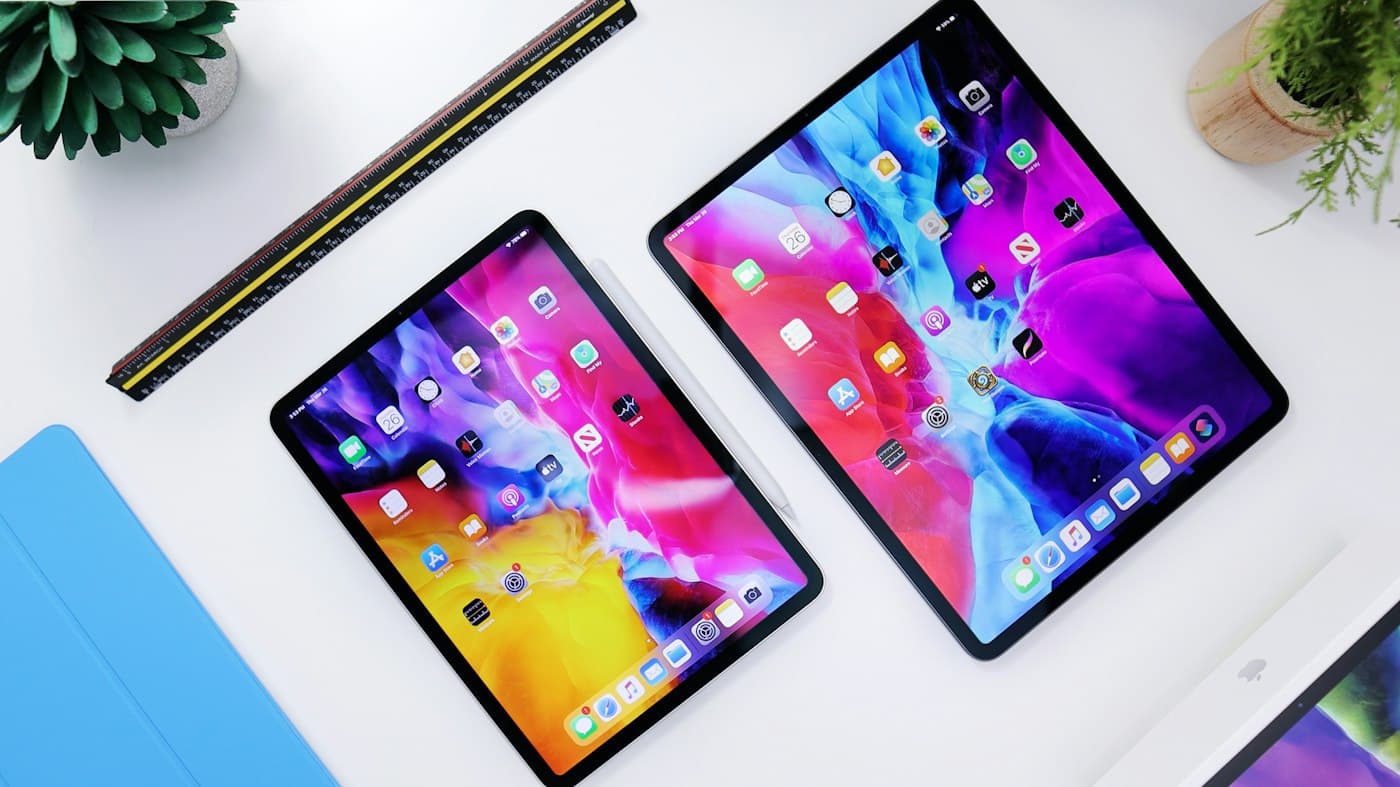 Twee tablets met kleurrijke schermen op een wit bureau